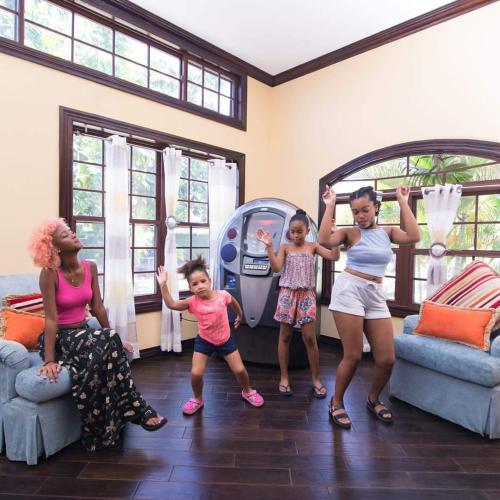 a group of women and children standing in a living room at Villa Dora Mae in Ocho Rios