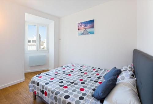a bedroom with a bed with a polka dot blanket at Wohnung Zentrum-Strand in Nice