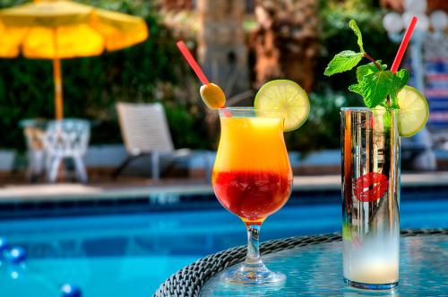 zwei Cocktails auf einem Tisch neben einem Pool in der Unterkunft Shalimar Hotel of Las Vegas in Las Vegas