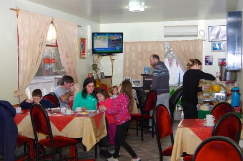 um grupo de pessoas sentadas em mesas em um restaurante em Rioma Hotel em Malargüe