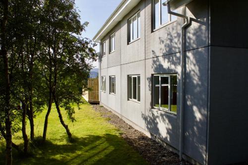 a building with a shadow on the side of it at Hótel Eyvindará in Egilsstadir