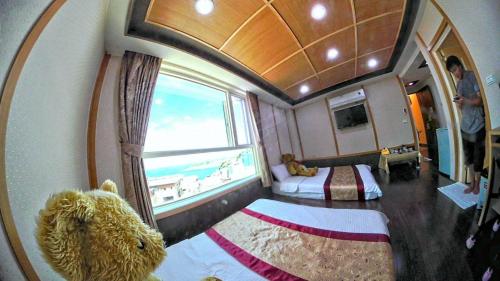 a teddy bear sitting in a room with a window at Shangrila in Dongyin