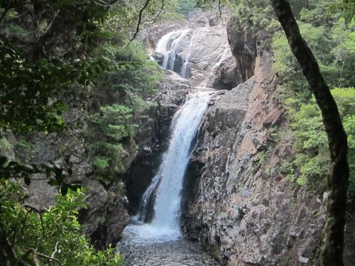 a waterfall in the middle of a rocky canyon at Yakushima Iwasaki Hotel in Yakushima