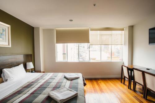 a bedroom with a bed and a desk and a window at YTI Garden Hotel in Melbourne