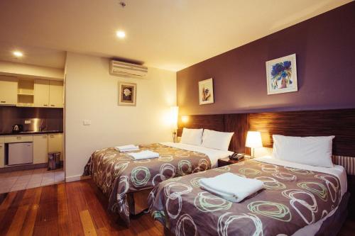 a hotel room with two beds and a kitchen at YTI Garden Hotel in Melbourne