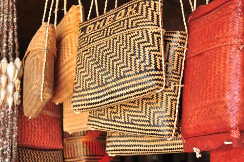 a bunch of purses are hanging in a store at Mu Homestay in Tetebatu