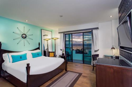 a bedroom with a large bed and a large window at Wave Hotel Pattaya in Pattaya Central