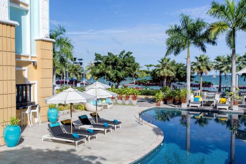 a pool at the resort with chairs and umbrellas at Wave Hotel Pattaya in Pattaya