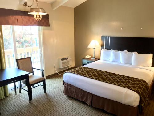 a hotel room with a large bed and a desk at Fireside Inn in Morro Bay