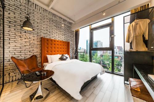 a bedroom with a white bed and a brick wall at Cullinan Gaepo in Seoul