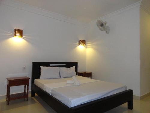 sypialnia z łóżkiem z dwoma światłami na ścianie w obiekcie Green Park Village Guesthouse w Siem Reap