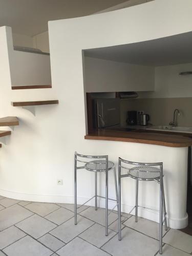 2 tabourets de bar devant un comptoir de cuisine dans l'établissement Boutique Hotel de la Place des Vosges, à Paris