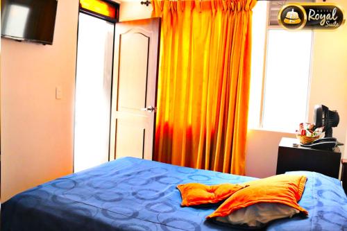 a bedroom with a bed and a window with curtains at Hotel Royal Suite in Manizales