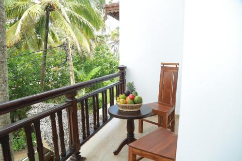 a bowl of fruit on a table on a balcony at Hotel Sanmark in Ahangama