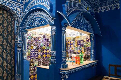 a blue room with a window with tiles on the wall at Haveli Kalwara - A Heritage Hotel in Jaipur