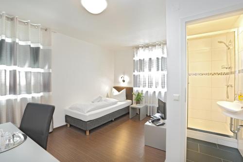 ハイルブロンにあるPension Arkade Heilbronnのベッドルーム1室(ベッド1台、シンク付)、バスルーム1室が備わります。
