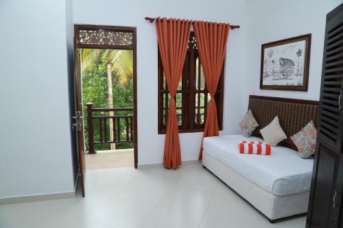 a living room with a couch and a window at Hotel Sanmark in Ahangama