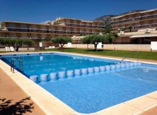 a large blue swimming pool in front of a building at Apartament Agutzil de Mar in Alcanar