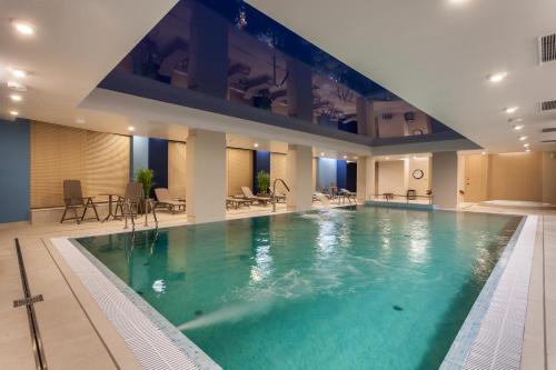 a large swimming pool in a hotel room at GRANO APARTMENTS Gdańsk Nowa Motława SPA & Wellness in Gdańsk