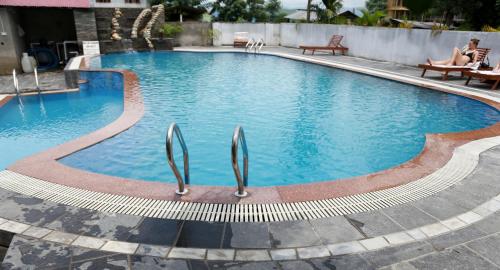 a large swimming pool with blue water at Hotel Parkland in Sauraha