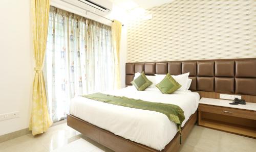 a bedroom with a large bed and a window at Treebo Pechis Castle in Chennai