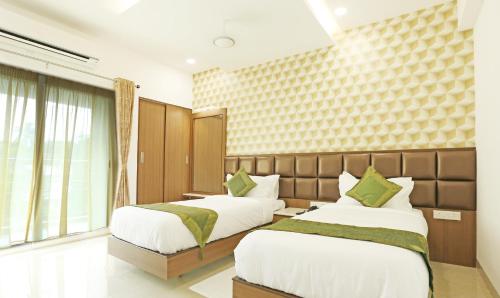 a bedroom with two beds and a window at Treebo Pechis Castle in Chennai