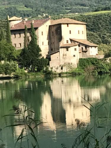 an old building on a hill next to a body of water at B&B al Capitello in Trento