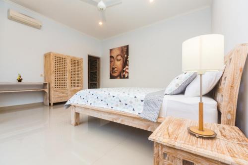 ein Schlafzimmer mit einem Bett und einem Tisch mit einer Lampe in der Unterkunft Castro Villa in Seminyak