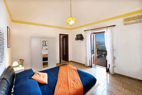 コンカ・デイ・マリーニにあるCasa Angelaのベッドルーム(青いベッド1台、バルコニー付)