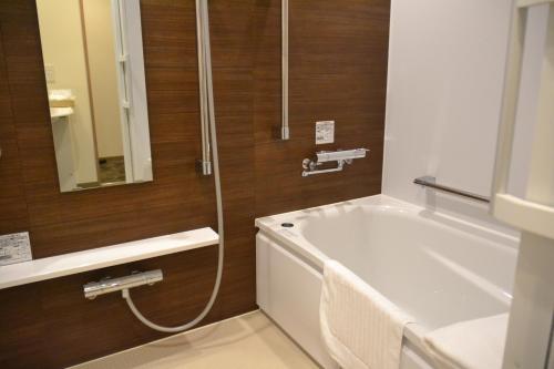 
a bathroom with a bath tub, toilet and sink at Rembrandt Style Tokyo Nishikasai Grande in Tokyo
