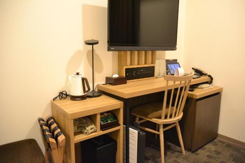 a computer desk with a television and a chair at Rembrandt Style Tokyo Nishikasai Grande in Tokyo