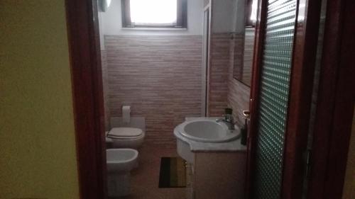bagno con lavandino, servizi igienici e finestra di Bilocale vista mare a Costa Rei