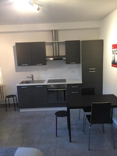 カンヌにあるStudio 1 proche Croisetteのキッチン(黒いキャビネット、テーブル、椅子付)
