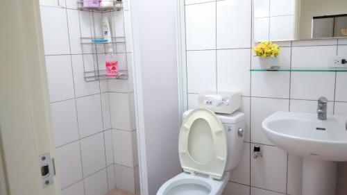 a white bathroom with a toilet and a sink at Beauty Chen's House in Tianwei