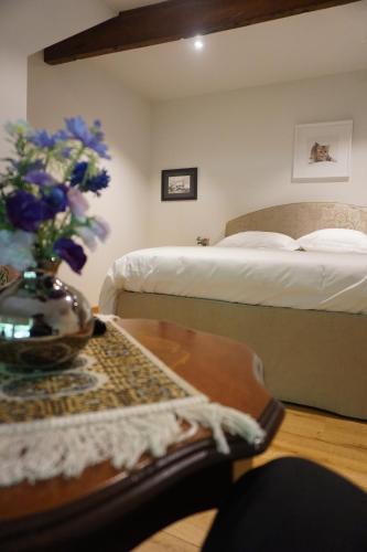 a bedroom with two beds and a table with a vase of flowers at B&B Domein Rodin in Oud-Turnhout