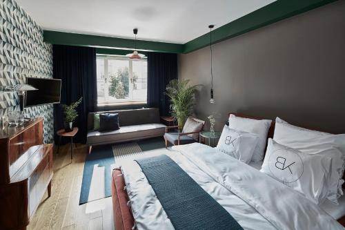 a bedroom with a large bed and a television at Bez Kantów Boutique Rooms in Warsaw