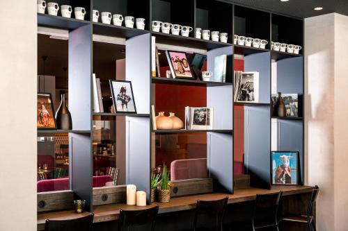 a room with a table with chairs and shelves at BOMA easy living hotel in Strasbourg