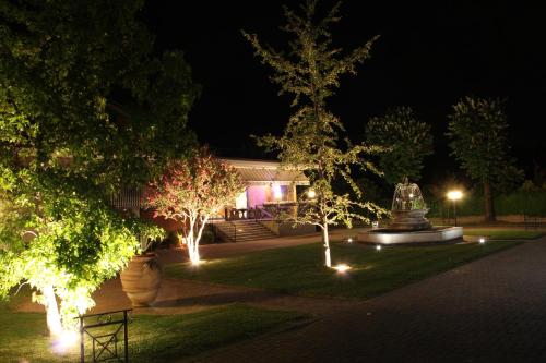 a building with lights in a park at night at Albergo Aurora in Castenaso