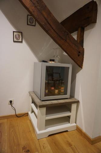 a tv sitting on a stand in the corner of a room at B&B Domein Rodin in Oud-Turnhout