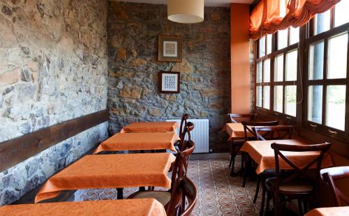 una fila de mesas en un restaurante con ventanas en Hotel Casona Cuervo, en San Tirso de Candamo