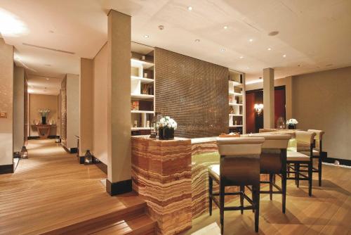 a restaurant with a bar with chairs and a table at The Trans Luxury Hotel Bandung in Bandung