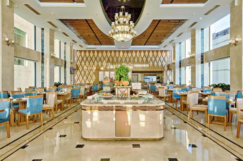 a dining room with tables and chairs and a chandelier at Paris Deli Danang Beach Hotel in Da Nang