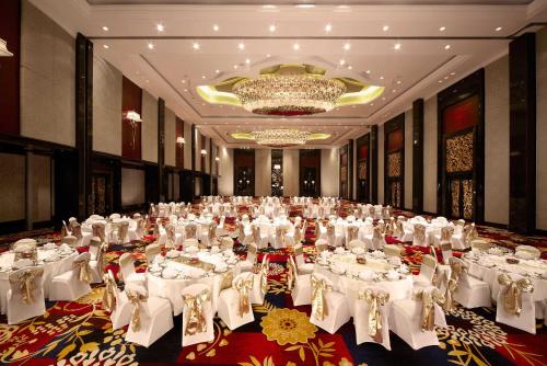 a large banquet hall with white tables and chairs at The Trans Luxury Hotel Bandung in Bandung