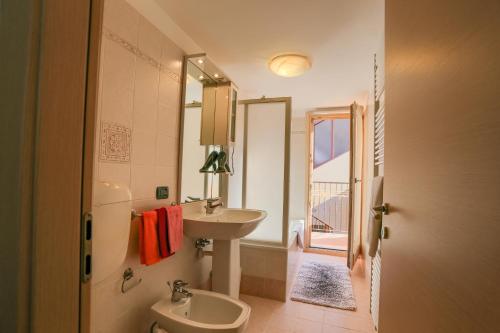 a bathroom with a sink and a toilet and a mirror at Casa Indipendente Ischia in Arco