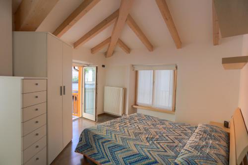 a bedroom with a bed and a dresser and windows at Casa Indipendente Ischia in Arco