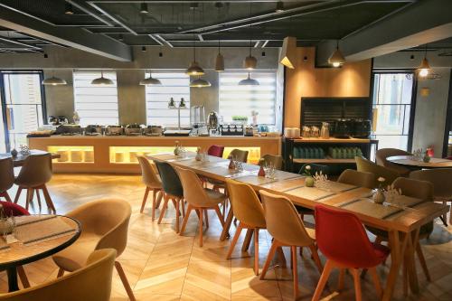 un restaurant avec une grande table et des chaises dans l'établissement Atourlight Hotel Xi'an University City Store, à Xi'an