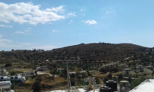 a view of a hill with houses and a city at Studio Galatia, in the heart of Kamilari in Kamilari