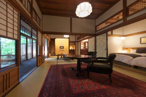a bedroom with a bed and a desk and a table at Sekizenkan Kashotei Sanso in Nakanojo