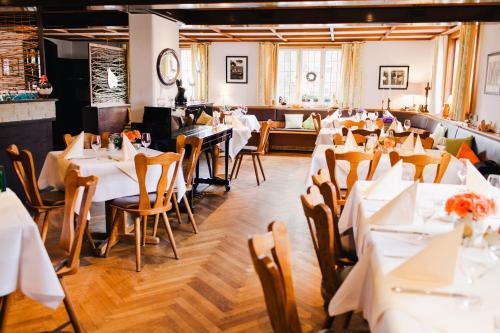 Un comedor con mesas y sillas blancas. en Hotel Linde Durbach, en Durbach