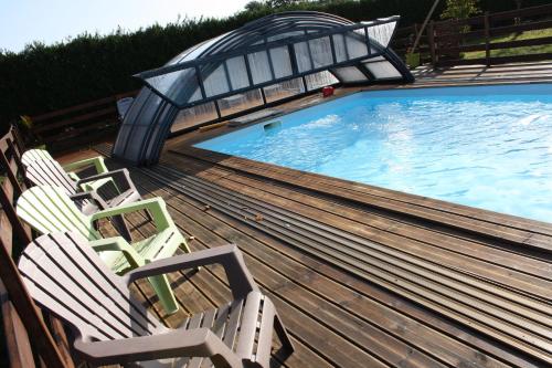 un groupe de chaises assises à côté d'une piscine dans l'établissement Le Charleston, à Huisnes-sur-Mer